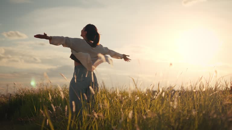 woman triumphantly standing in a field